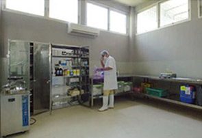 Worker in a clean lab room checking items on a shelf